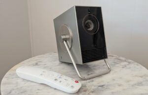 LG Cinebeam Q 4K Revisão do projetor: Eu posso decidir com minha TV para sempre Um projetor LG Cinebeam Q 4K fica em um refrigerador, com o menu LG Webos mostrado em uma tela do Project Roon