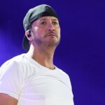 Luke Bryan cai durante o show depois de cair no telefone celular dos fãs