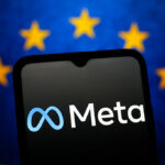 The Meta Platforms logo is seen displayed on a smartphone screen and the flag of the European Union in the background.