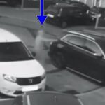 Uma mulher vestida com uma jarra pode ser vista se aproximando de um SUV preto e atirar em uma arma, mas fica preso