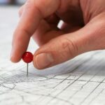 Muitos gerações Z Use Find Mina e outros aplicativos para compartilhar sua posição com grupos de amigos 24/7 | A foto mostra uma mão posicionando um pivô em um mapa