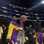 O Los Angeles Lakers protegeu Bronny James e aqueceu LeBron James antes de uma partida de basquete da NBA contra o Minnesota Timberwolves em Los Angeles em 22 de outubro de 2024.