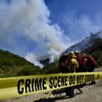 Um pequeno incêndio quebra no pincel como bombeiros ...