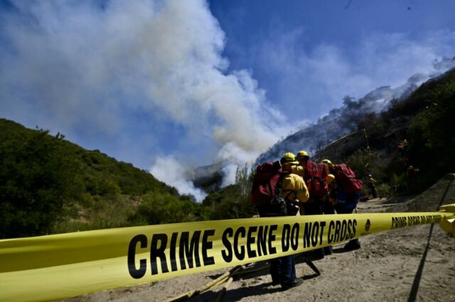 Um pequeno incêndio quebra no pincel como bombeiros ...