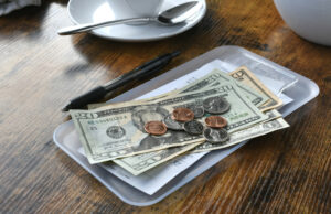 O homem termina o prato, não preparado para o motivo pelo qual o servidor está esperando o banho O homem termina o prato, não preparado para o motivo pelo qual o servidor está esperando o banho