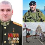 Divisão Geral Michail Gudkov de uniforme, com um navio de guerra em segundo plano.