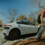 A Waymo robotaxi on the street in Phoenix and a teenage girl walking away from it.