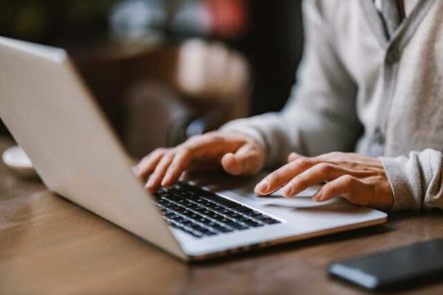 Fechar -Up of Writing Hands em um laptop em um café.
