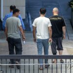 Um grupo de homens afegãos sai do hotel Bracknell. Os habitantes locais não foram informados das reais razões pelas quais tantos afegãos vêm aqui - que o governo britânico os colocou em perigo