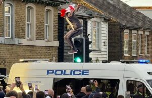 Os protestos de hotéis migrantes espalhados pelo Reino Um manifestante pula para cima e para baixo no teto de um carro da polícia em um protesto em 17 de julho fora do hotel Bell