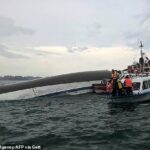 A equipe de ajuda se reuniu em torno de um barco turístico aninhado, que transportou 53 passageiros quando fechado - deles são acreditados pelo menos 27 ha mortos
