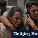 Os palestinos agirem depois de levar os corpos mortos enquanto tentavam ajudar os caminhões que entram no norte de Gaza.