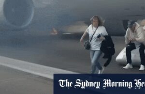 Os viajantes voam de avião fumante no slide de emergência no aeroporto de Denver Os viajantes voam de avião fumante no slide de emergência no aeroporto de Denver