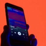 O Spotify afeta 696 milhões de usuários, mas retornou a uma perda | Aplicativo Vista em um smartphone em um fundo colorido