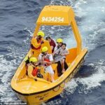 Uma menina de cinco anos senta -se no joelho da embarcação depois que ela e o pai foram resgatados depois de cair no mar do Disney Dream Cruise Ship no domingo de manhã