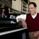 O músico Tom Lehrer fica ao lado do piano em sua casa em Santa Cruz, Califórnia, em 21 de abril de 2000.