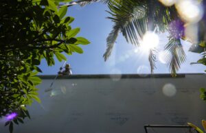 Uma ADU combatida está oficialmente terminada. Dois vizinhos da Califórnia não podem ser guerras de guerra. Na terça -feira, 29 de julho de 2025, um trabalhador pressiona em San Diego entre uma cerca e uma parede para terminar um ADU. (Ana Ramirez / The San Diego Union-Tribune)