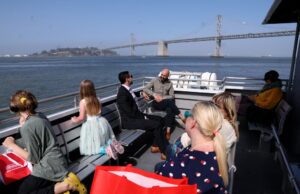 Vá a bordo dessas quatro fantásticas viagens de balsa na área da baía Wiliam Fellker, de São Francisco, o segundo da esquerda, e outros estão esperando a balsa na Baía de São Francisco no domingo, 1º de junho de 2025, em 1º de junho de 2025 na doca da Main Street Alameda Ferry Terminal, em Alameda, Calified. Felker comprou uma lâmpada na vizinha Alameda Point Antiques Faire. (Jane Tyska/Bay Area News Group)