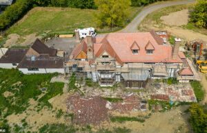 O Hoje: toda a fachada da casa falsa é revestida de andaimes com materiais de construção, incluindo tábuas de madeira, espalhadas na calçada