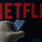 Uma pessoa está segurando um controle remoto de TV com a Netflix visível em segundo plano na foto nesta ilustração tirada em Bruxelas, Bélgica, em 5 de maio de 2024 (foto de Jonathan Raa / Nurphoto)