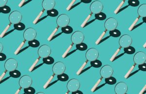 A regulamentação da verificação de idade do Reino Unido parece estar prejudicando sites que permanecem, ajudando aqueles que não Magnifying Glass Focusing Sunlight Into a Point Repetition on Turquoise Colored Background High Angle View.