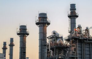 A usina a gás de US $ 10 bilhões da Meta Datacenter aprovou, mas nem todos estão felizes Natural gas power plant smoke stacks stand against a twilight sky.