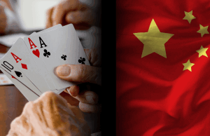 Cinco funcionários de Hubei punidos pelo Partido Comunista Chinês por jogos inadequados O Partido Comunista Chinês pune cinco funcionários de Hubei por jogos de azar e tocação de cartas impróprias. Close-up de mãos segurando cartas de jogo, incluindo três ases, ao lado da bandeira nacional chinesa, simbolizando a repressão da China no jogo