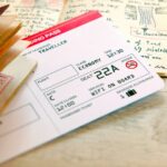 Pronto para voar e iniciar uma nova aventura de viagem: passaporte com selos, embarcando no bilhete de avião com diário de viagem manuscrito e diário com desenhos. Em um fundo de madeira.