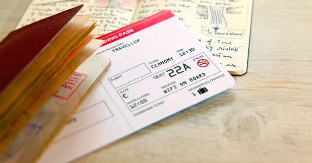 Pronto para voar e iniciar uma nova aventura de viagem: passaporte com selos, embarcando no bilhete de avião com diário de viagem manuscrito e diário com desenhos. Em um fundo de madeira.