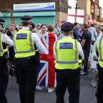 A polícia fica em frente a manifestantes do lado de fora do TLK Apartments & Hotel Housing Asylum Bounders em Orpington, Greater London