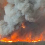 Uma imagem do ar mostra um incêndio florestal e uma fumaça espessa subindo no ar.