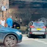 Um carro está lutando para dirigir ao redor do novo meio -pé -High Curb em Salisbury, Wiltshire