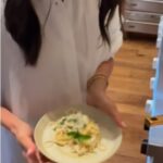 A duquesa de Sussex parecia estar de bom humor enquanto ela levantou um prato de macarrão enquanto vestia uma camisa branca crocante