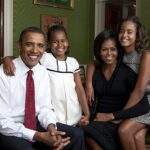 Michelle e Barack Obama retratados com as filhas Sasha (em branco) e Malia (em vestido com estampamento preto e branco) enquanto morava na Casa Branca em 2009