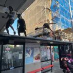 Três homens espalhados em tinta foram vistos dançando em cima de uma parada de ônibus do lado de fora da estação Ladbroke Grove, perto do mercado de Portobello Road