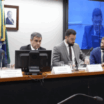 O Congresso do Brasil disse para se concentrar nas perdas de receita de jogo de US $ 6,4 bilhões no mercado negro. Um painel de quatro homens de terno sentado em uma longa mesa durante uma sessão formal do Congresso no Brasil. Uma bandeira brasileira e um retrato emoldurado na parede atrás deles. Papas de identificação e microfones estão posicionados na frente de cada alto -falante, junto com copos de água. Uma tela grande no fundo exibe um feed ao vivo da reunião.