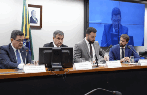 O Congresso do Brasil é instruído a concentrar a atenção nos US $ 6,4 bilhões em receitas de jogo perdidas no mercado negro O Congresso do Brasil disse para se concentrar nas perdas de receita de jogo de US $ 6,4 bilhões no mercado negro. Um painel de quatro homens de terno sentado em uma longa mesa durante uma sessão formal do Congresso no Brasil. Uma bandeira brasileira e um retrato emoldurado na parede atrás deles. Papas de identificação e microfones estão posicionados na frente de cada alto -falante, junto com copos de água. Uma tela grande no fundo exibe um feed ao vivo da reunião.