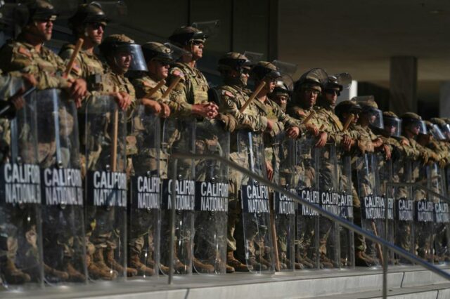 Arquivo - Membros da Guarda Nacional da Califórnia e fuzileiros navais dos EUA, a entrada fora do Wilshire Federal em Los Angeles, 13 de junho de 2025. (Stephen Lam/San Francisco Chronicle via AP, arquivo)