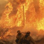 Uma habitação no carrinho de golfe de passeios na propriedade, enquanto o Canyon Fire queima em Hasley Canyon, Califórnia.