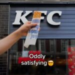 Greggs publicou um vídeo sobre mídia social de um de seus icônicos rolos de salsicha realizados em frente a um sinal de restaurante KFC