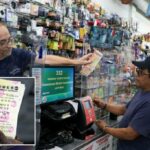 Um trabalhador da loja de Miami entrega os ingressos para um cliente em 26 de agosto de 2025.