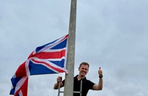 Robert Robert Jenrick escalou uma escada em seu distrito eleitoral de Newark para Hang Union Jacks de Lamp Posts