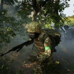 Um homem do Serviço de Guarda Nacional Ucraniano da 3ª Brigada passa por uma linha de árvores não muito longe da linha de frente na direção de Pokrovsk, Ucrânia, sexta -feira, 8 de agosto de 2025