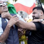 Um homem (à esquerda) que participa da marcha é agarrado pela garganta por outro homem, preso pela polícia após o incidente, durante a Marcha Nacional de Refém, no centro de Londres