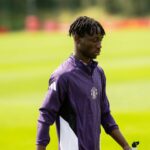 Sekou Kone anda com fones de ouvido e um rastreamento de Man Utd. Andre Onana fora do foco de fundo