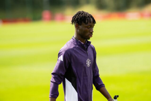 Sekou Kone anda com fones de ouvido e um rastreamento de Man Utd. Andre Onana fora do foco de fundo
