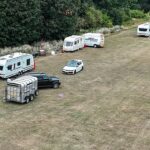 Um grupo de viajantes quebrou fechaduras e invadiu um parque afluente do norte de Londres, com até 15 caravanas ilegalmente lançadas ao lado de casas de vários milhões de libras