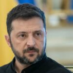 Retrato da cabeça e braços de Volodymyr Zelensky.