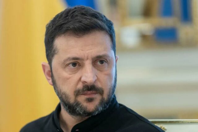 Retrato da cabeça e braços de Volodymyr Zelensky.