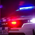 Um carro da polícia da QLD Kia à noite com suas sirenes em